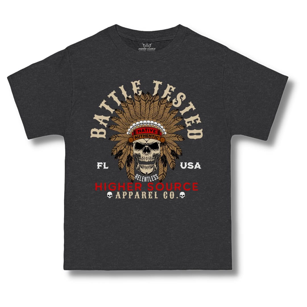 Front side of a charcoal heather grey higher source apparel oversized t shirt with battle tested in large dark vanilla font and an apache skull in the center. Higher Source apparel company is at the bottom in red and dark vanilla font.
