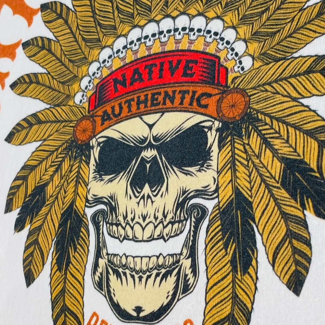 A white higher source apparel t shirt with an apache skull wearing a feather headdress.