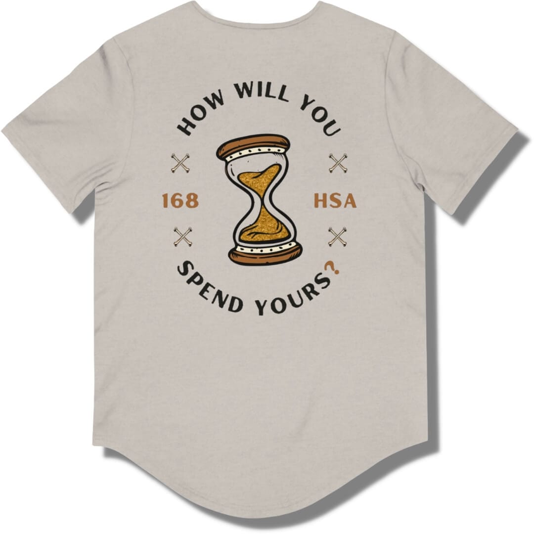 Back side of a heather cool grey curved hem t shirt with "how will you spend yours" in an oval shape. The font is in black and gold with an hour glass in the center.