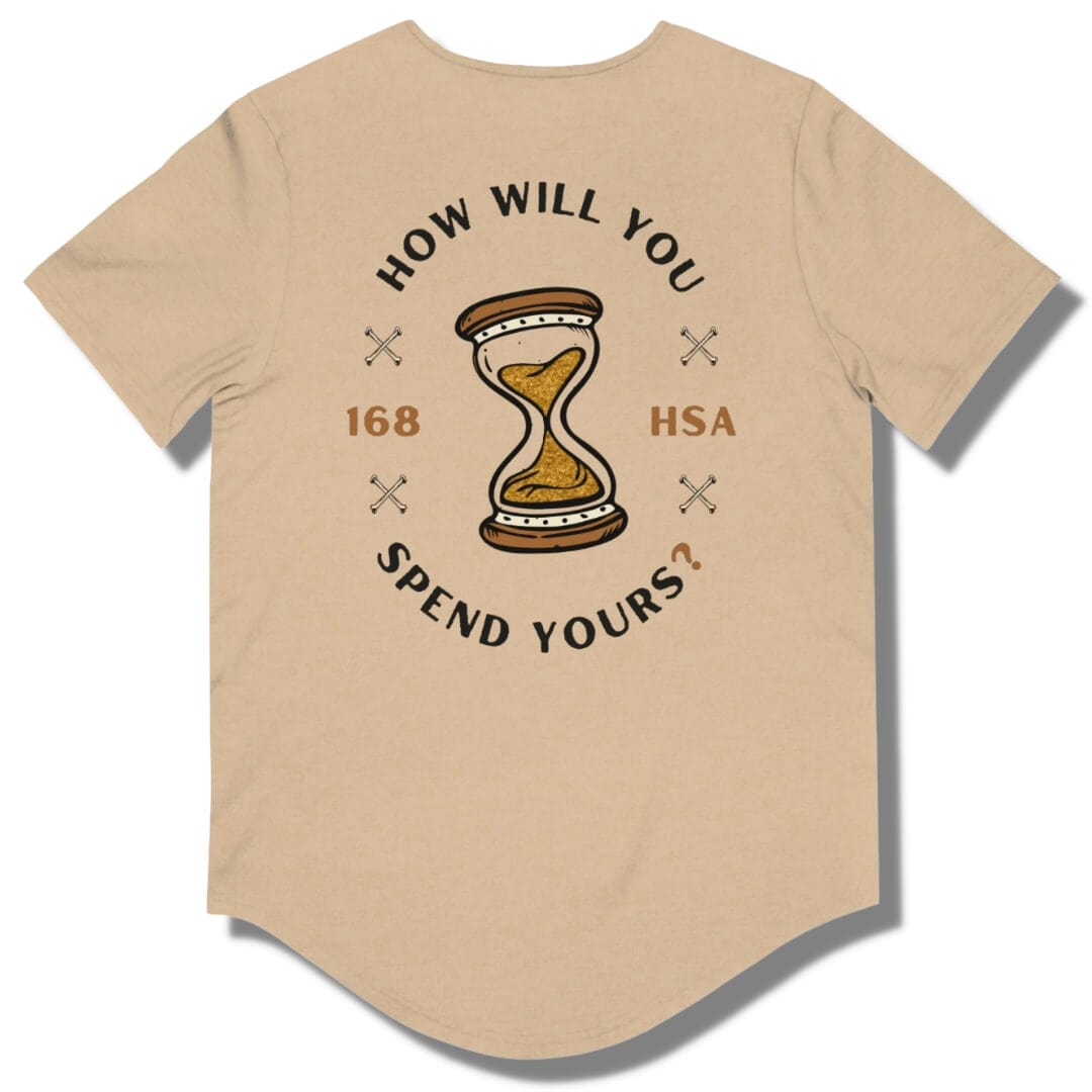 Back side of a heather sand dune curved hem t shirt with "how will you spend yours" in an oval shape. The font is in black and gold with an hour glass in the center.