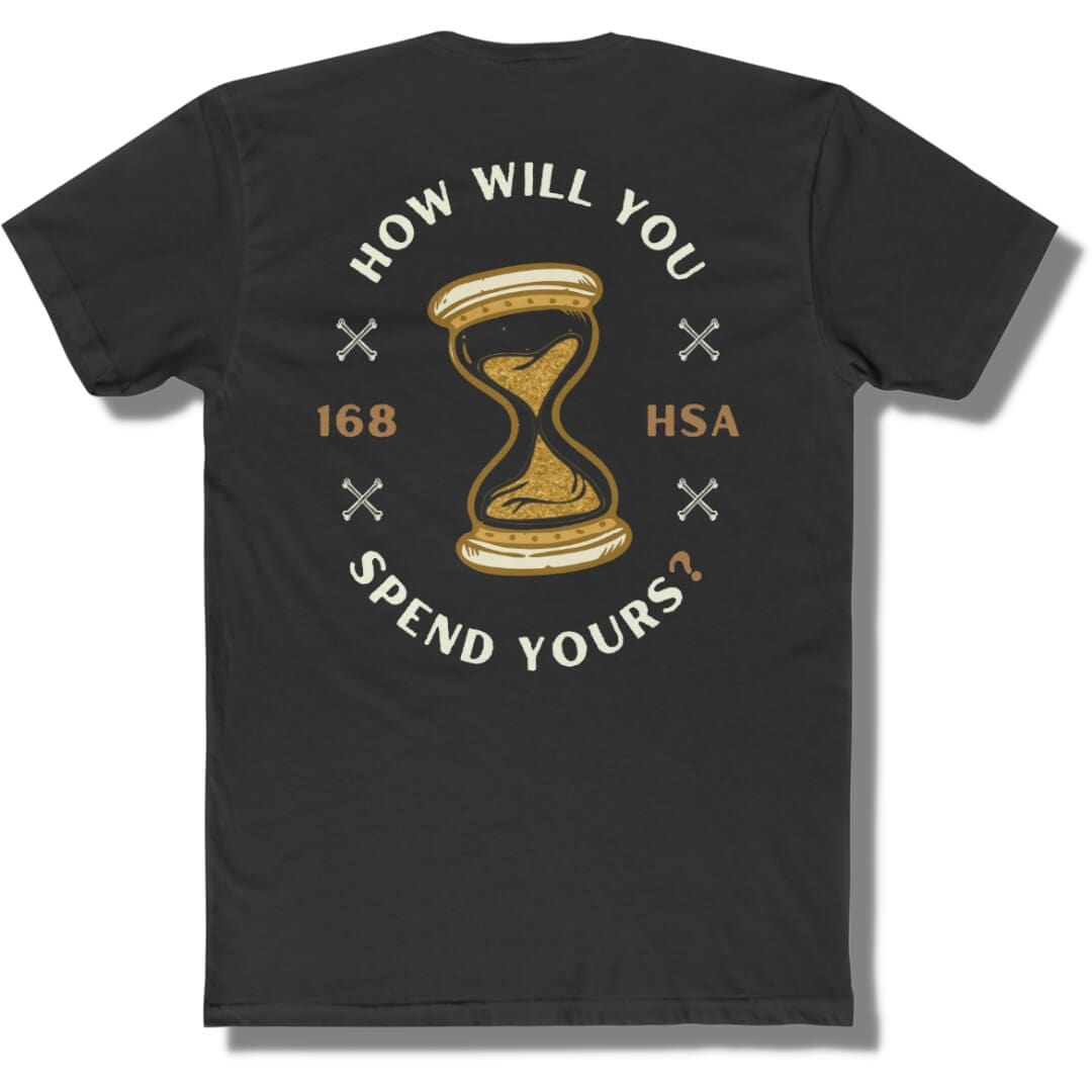 Back side of a black t shirt with "how will you spend yours" in an oval shape. The font is in off white and gold with an hour glass in the center.