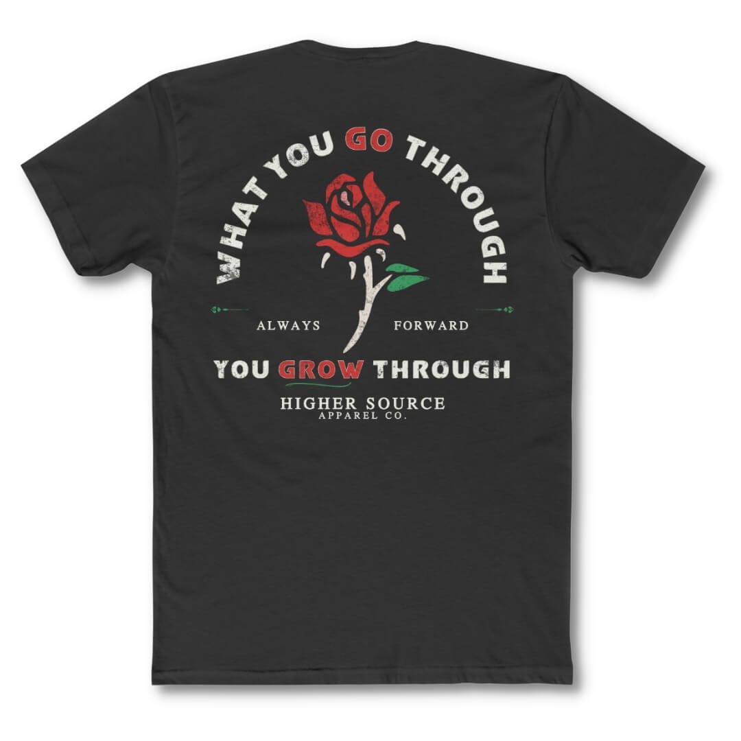 Back side of a black higher source apparel t shirt with “what you go through, you grow through in pastel grey and lava red font. There is a lava red and green rose in the center of the logo.