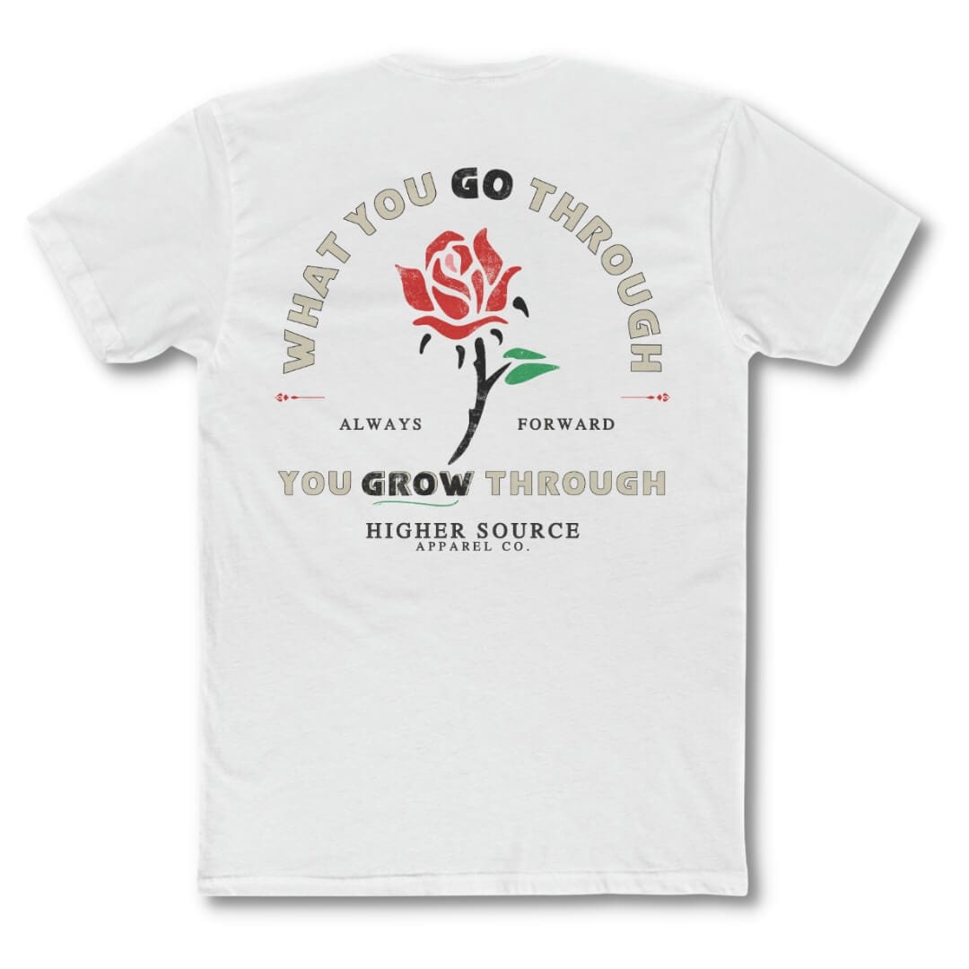 Back side of a white t shirt with “what you go through, you grow through in a distressed style with pastel grey and black font. There is a lava red and green rose in the center of the logo.