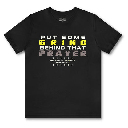 Front side of a black higher source apparel women's t shirt with “put some grind behind that prayer” in white, maximum yellow, and taupe gray font. 